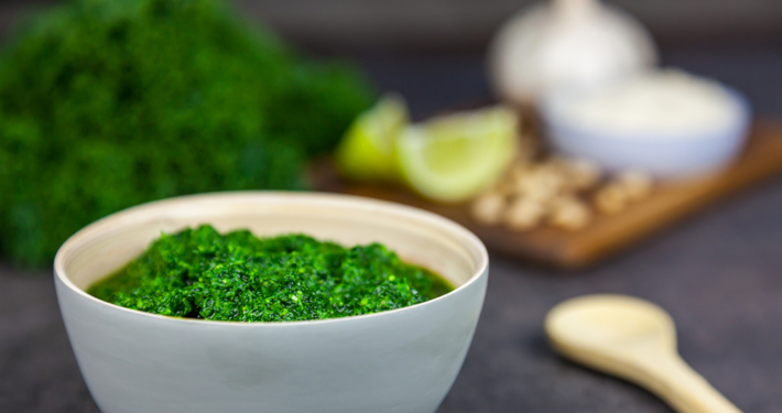 Pesto from kale. Kale, cheese, lemon, pine nuts and garlic on the background